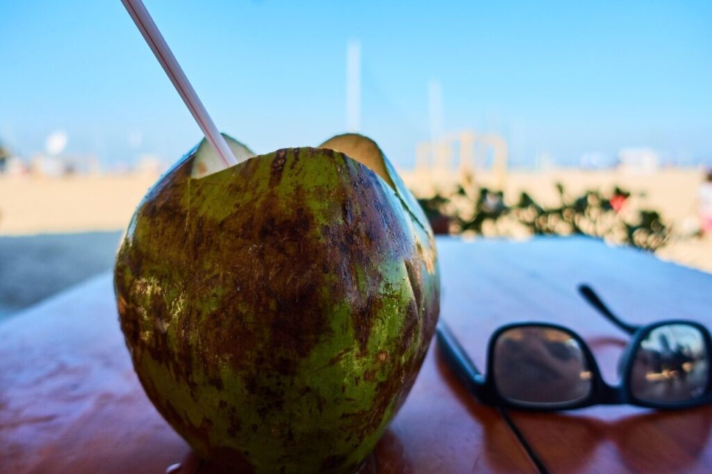 Fresh coconut with a straw at a beach kiosk on the Rio waterfront