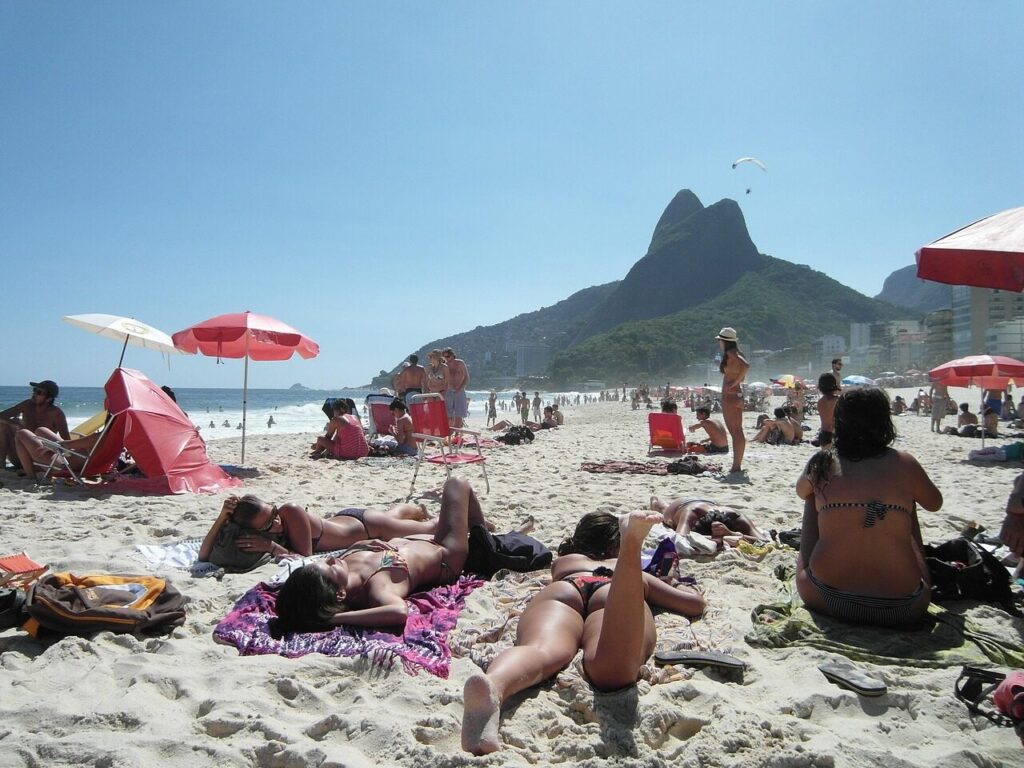 Sunbathers and umbrellas along Copacabana beach on a clear summer afternoon
