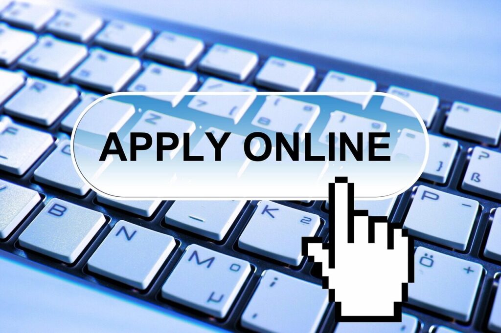 Traveler filling out an online visa application on a laptop at a desk
