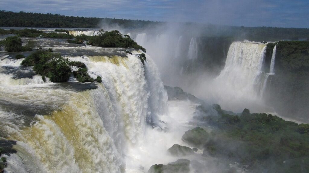 Visitors on the Brazilian walkway facing the wide curtain of Iguazu cascades